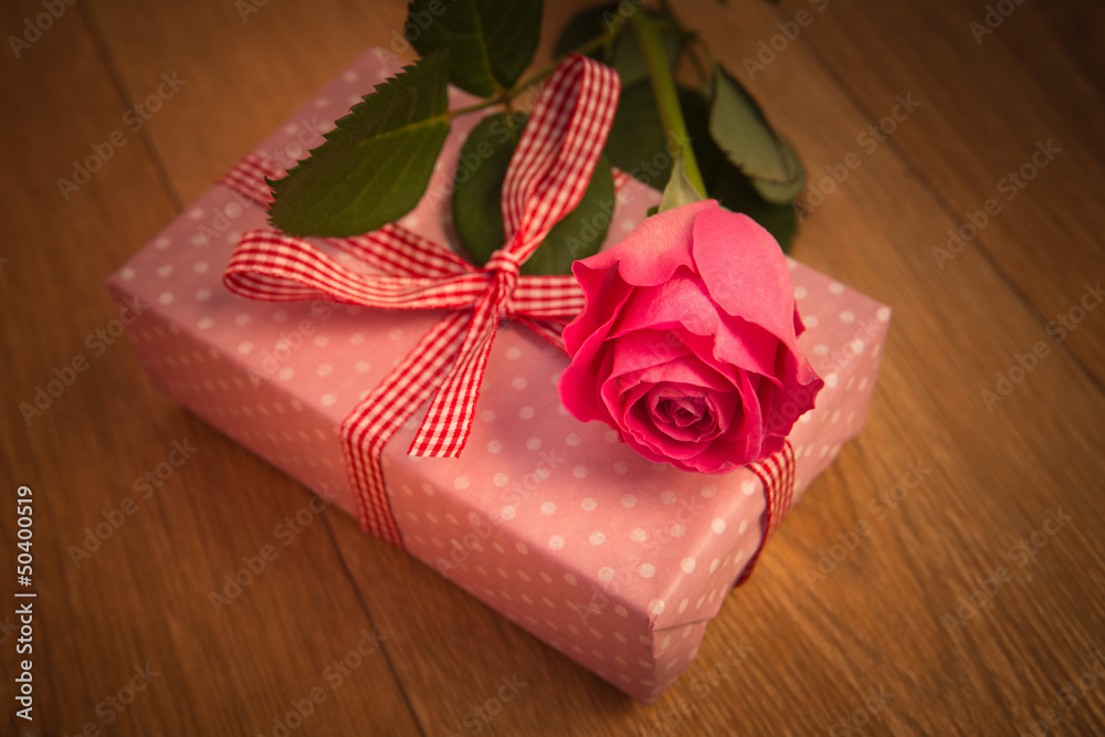 Pink wrapped present with pink rose and vignette frame Pink wrapped present with pink rose and vignette frame