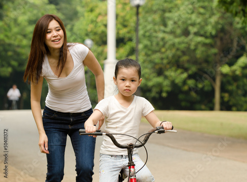 chinese mother having good time on bicycle with her daughter