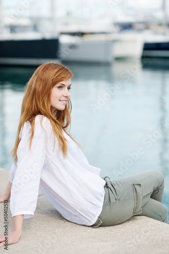 junge frau sitzt am hafen © contrastwerkstatt