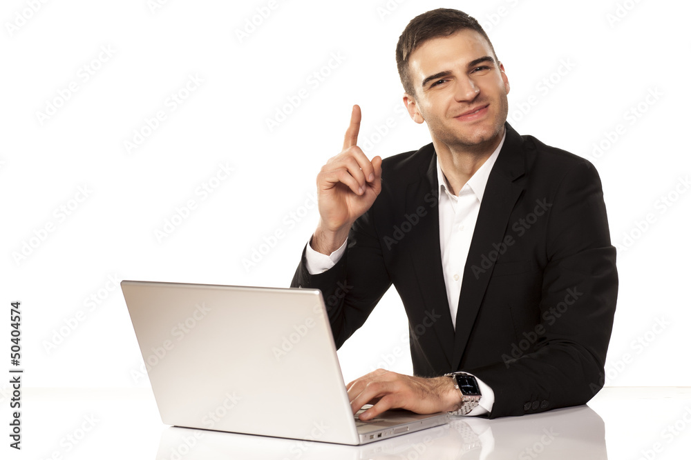 attractive businessman shows his finger up behind his laptop attractive businessman shows his finger up behind his laptop