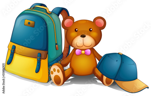 A backpack, a bear and a baseball cap