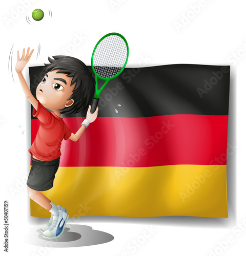 A boy playing tennis in front of a flag
