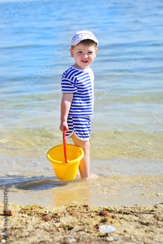 a little boy playing on the sea-shore in summer