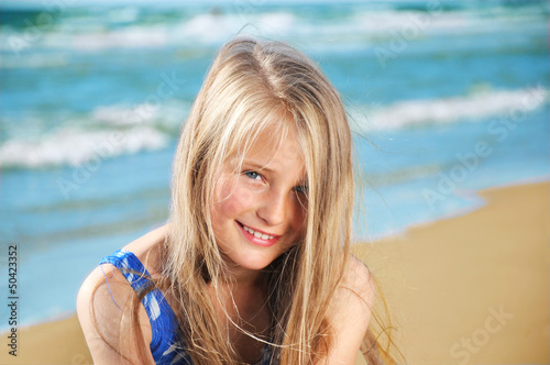 Portrait of little girl on a sandy beach © Shmel