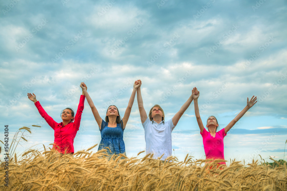 Four young people staying with raised hands