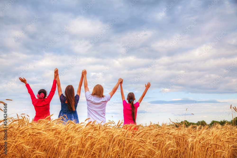 Four young people staying with raised hands