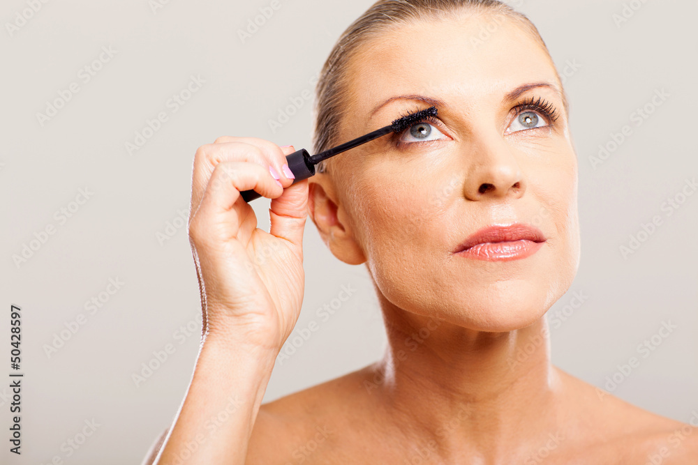 senior woman putting mascara