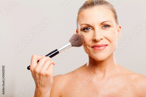 beautiful mature woman applying make up