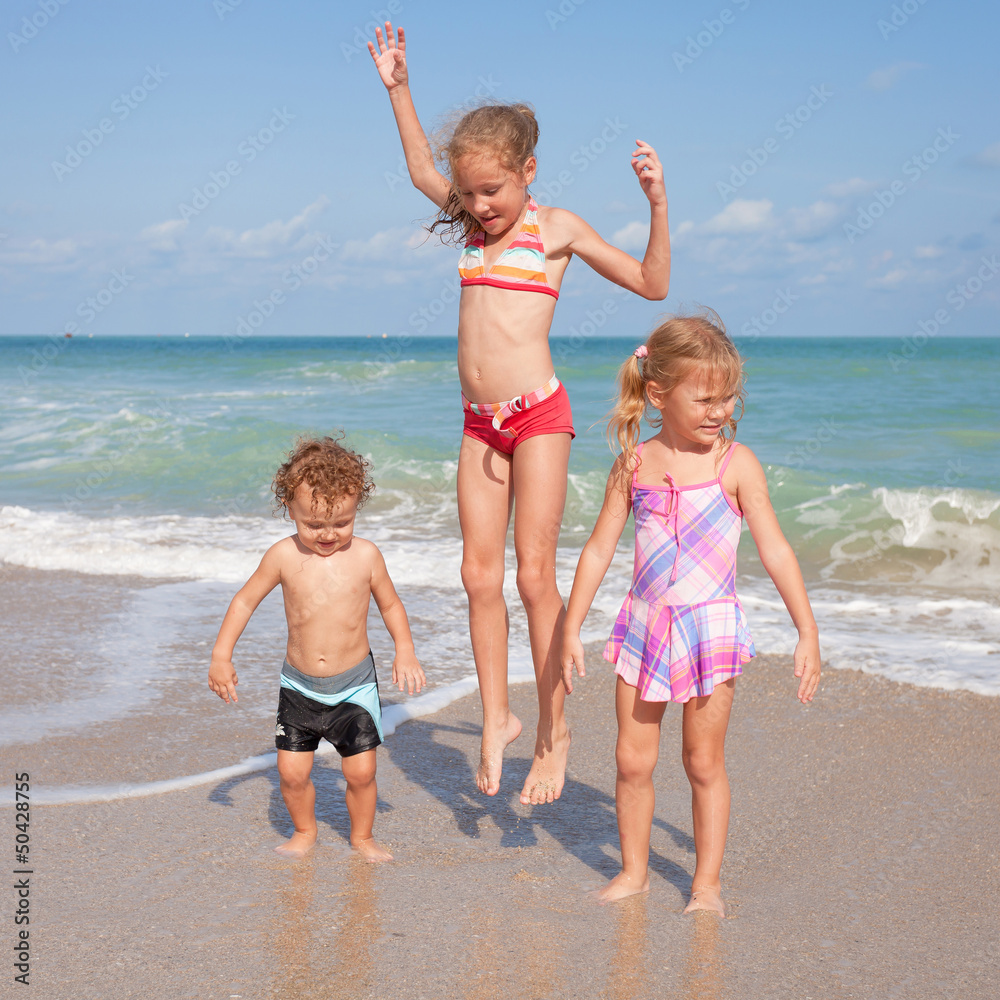 Naklejka premium happy kids playing on beach