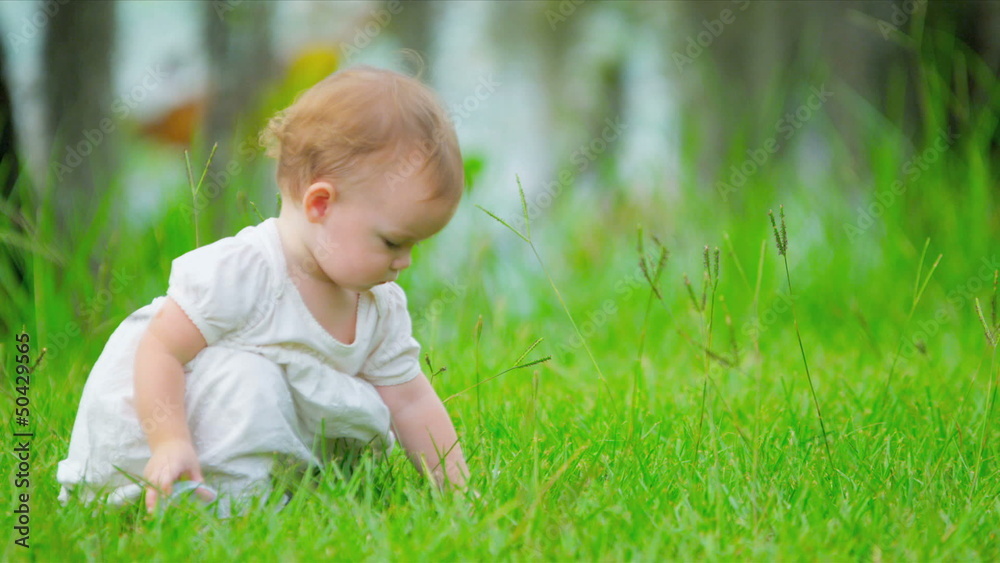 Caucasian toddler playing in green garden Caucasian toddler playing in green garden