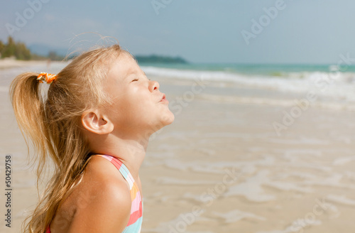 Adorable happy smiling girl on beach vacation