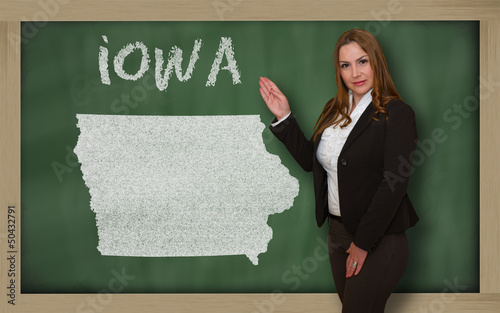 Teacher showing map of iowa on blackboard photo