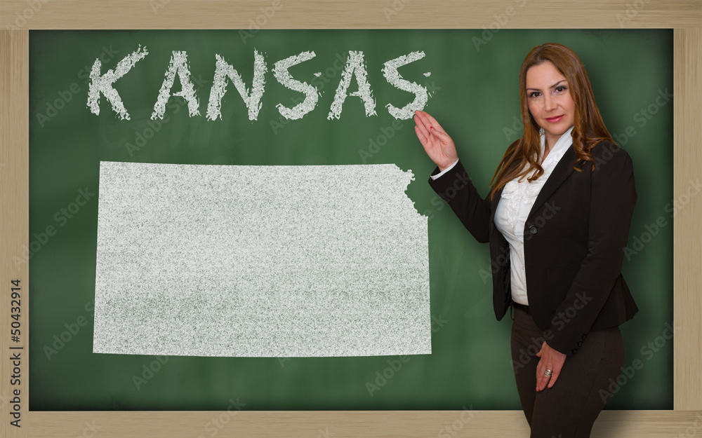 Teacher showing map of kansas on blackboard