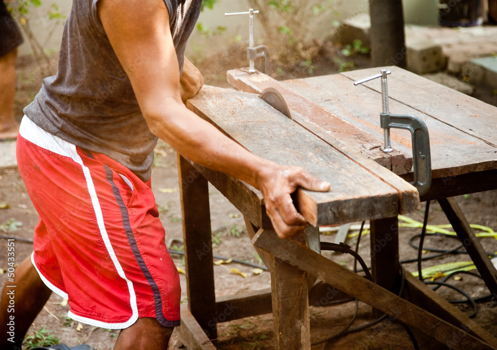 Man working on a saw. Man working on a saw.