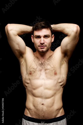 Topless man stood on a black background