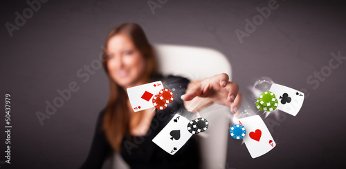 Young woman playing with poker cards and chips