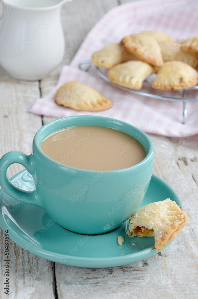 Cup of coffee with milk and apple pies on wooden background Cup of coffee with milk and apple pies on wooden background