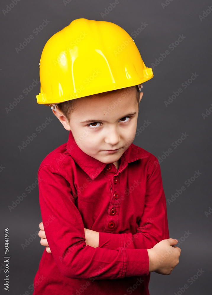 Portrait of a cute little boy with hardhat and arms folded