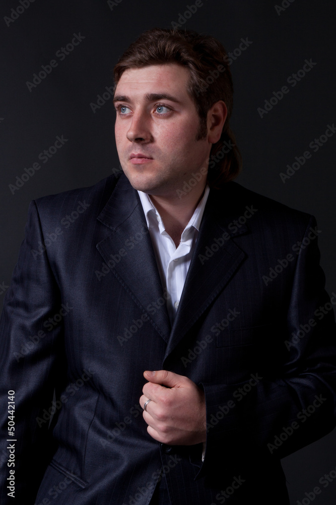 man in a black suit with a gray background man in a black suit with a gray background