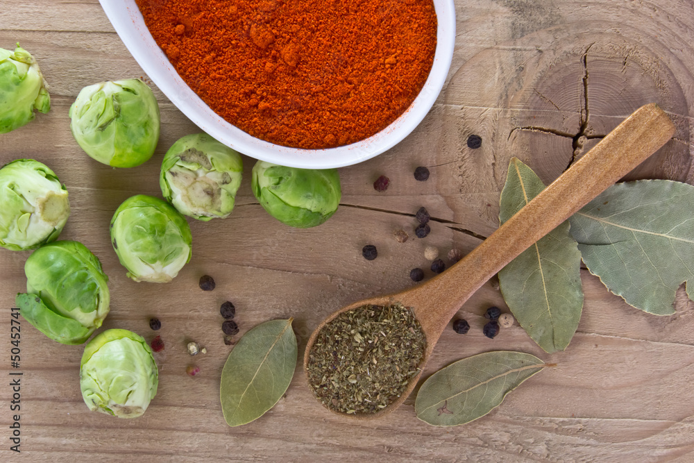 spices and fresh raw brussels sprouts on a wooden table