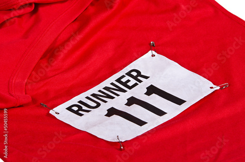 Race number on bib attached to the front of red running shirt