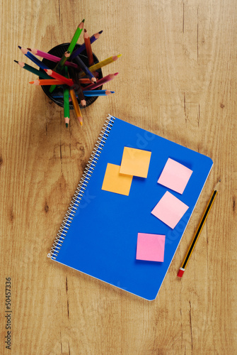 Cuaderno y lápices de colores en un bote photo