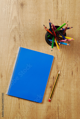 Cuaderno y lápices de colores en un bote photo