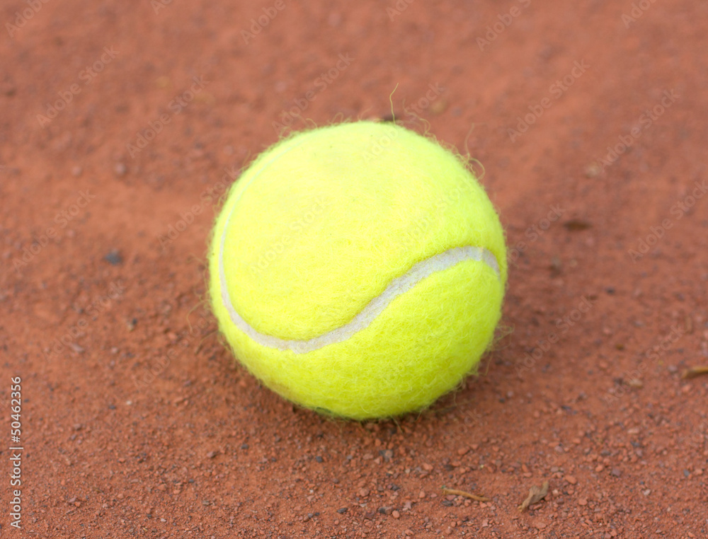 Tennis ball close up on red ground