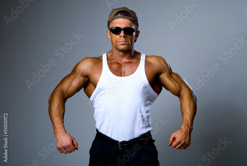 Handsome muscular man in dark glasses and a white shirt © kanzefar
