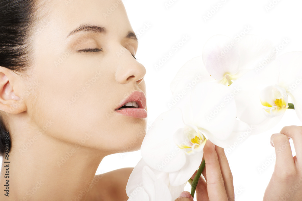 Young woman with health skin and with orchid flower Young woman with health skin and with orchid flower