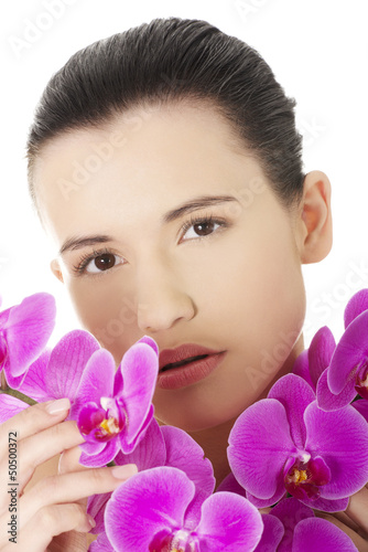 Young woman with health skin and with orchid flower