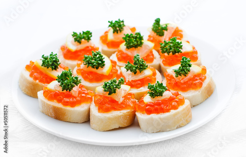 Canapes with salmon caviar, lemon and parsley