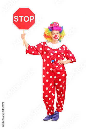 Full length portrait of a clown holding a stop sign