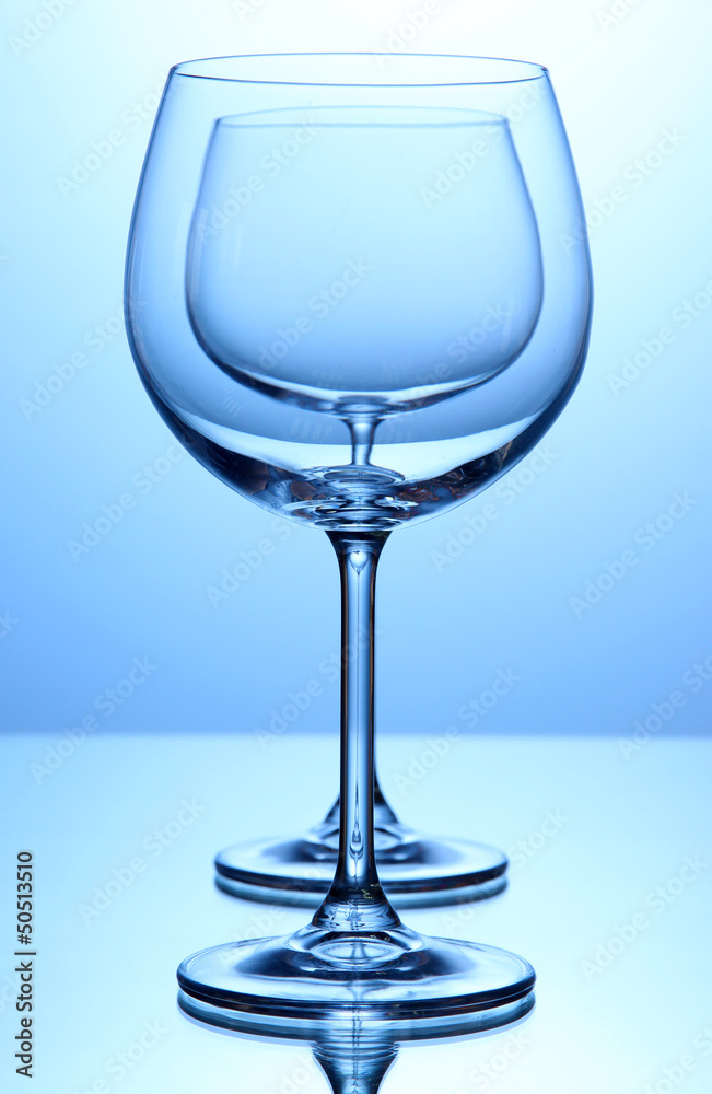 Empty wine glasses arranged on blue background Empty wine glasses arranged on blue background