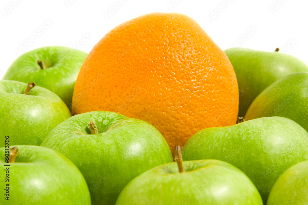 Orange in a pile of green apples Orange in a pile of green apples
