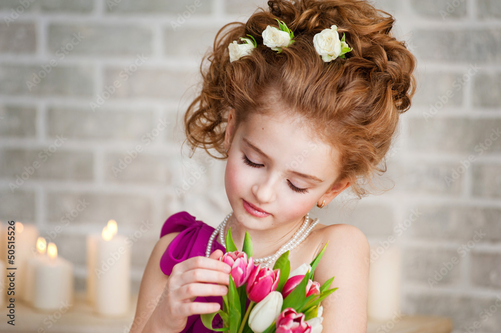 Naklejka premium Portrait of a beautiful girl with tulips