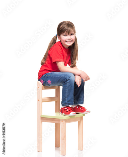 little girl wearing red t-short and posing on chair