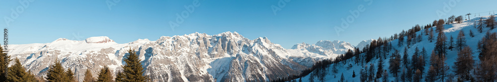 Panorama of winter snow mountain landscape with blue sky.