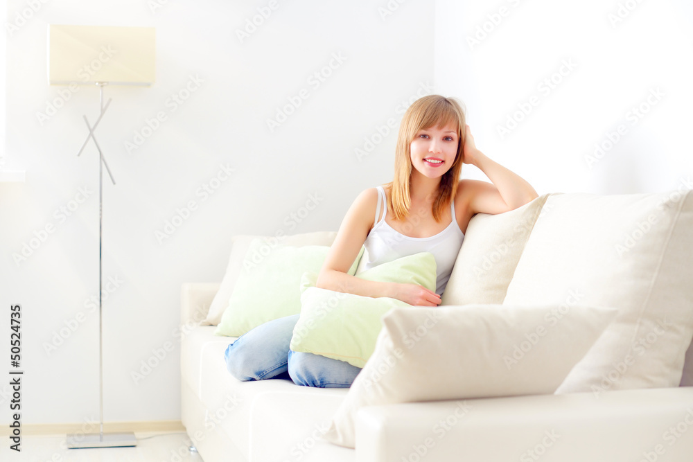 smiling girl sitting on sofa smiling girl sitting on sofa