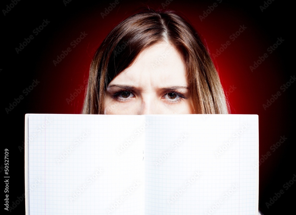 Disappointed and angry young girl holding exercise book Disappointed and angry young girl holding exercise book
