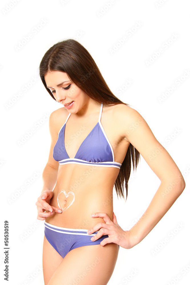 Woman with a heart shape made from suntan cream on her tummy Woman with a heart shape made from suntan cream on her tummy