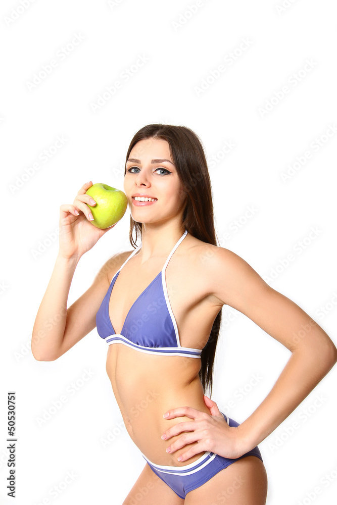 Young woman standing in bikini with apple on white background Young woman standing in bikini with apple on white background
