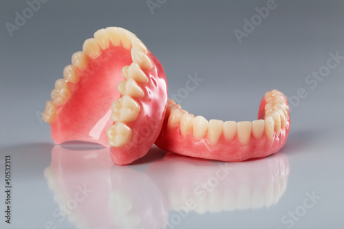 A set of dentures on a shiny gray background photo