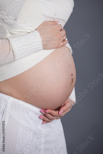 pregnant woman touching her belly with hands