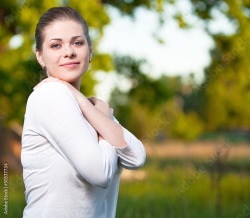 beautiful young white woman standing against nature green 