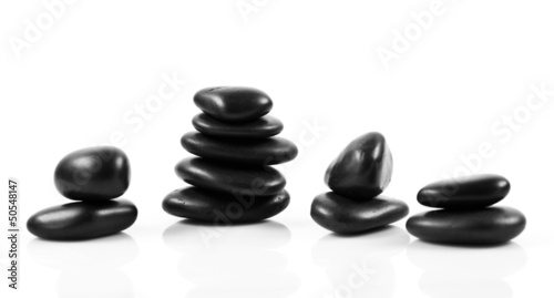 Black massage stones stacked, isolated.