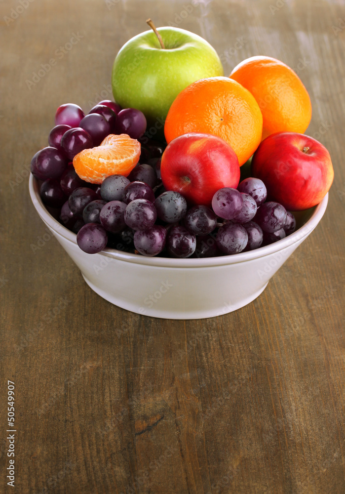 Bowl with fruits, on wooden table Bowl with fruits, on wooden table