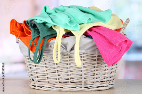 Clothes in wooden basket on table in room