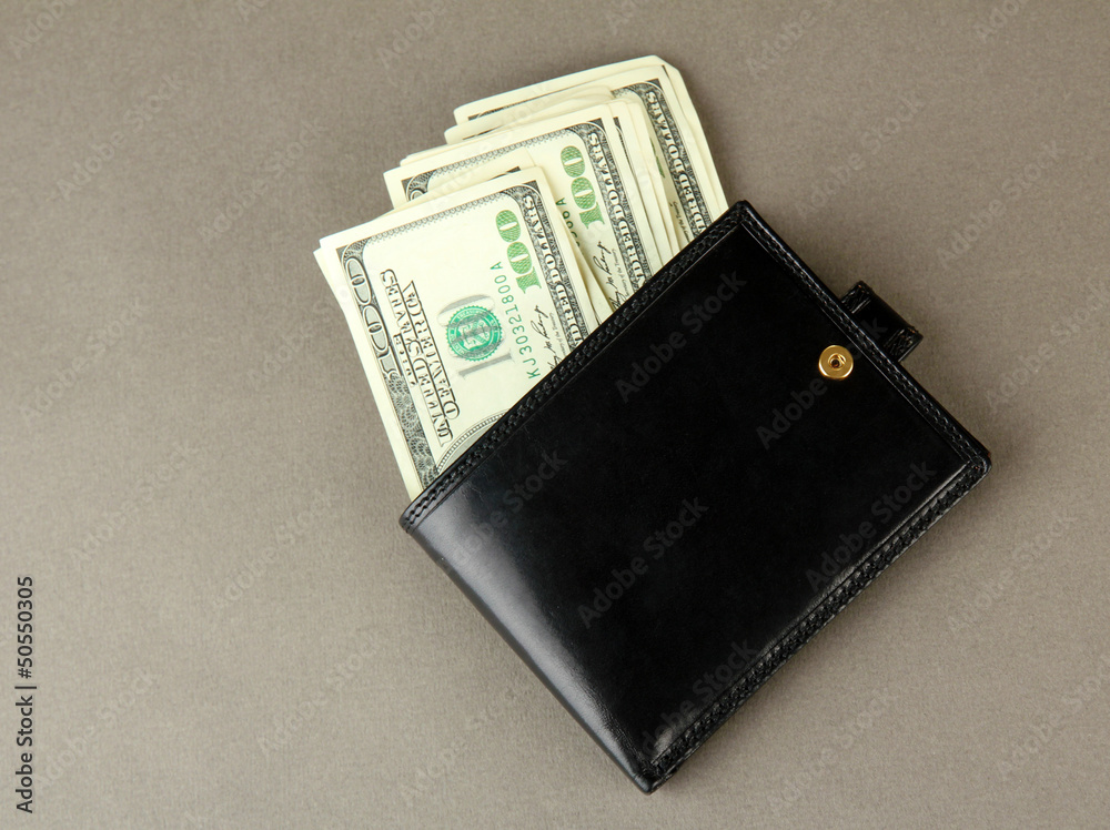 Wallet with hundred dollar banknotes, on color background Wallet with hundred dollar banknotes, on color background