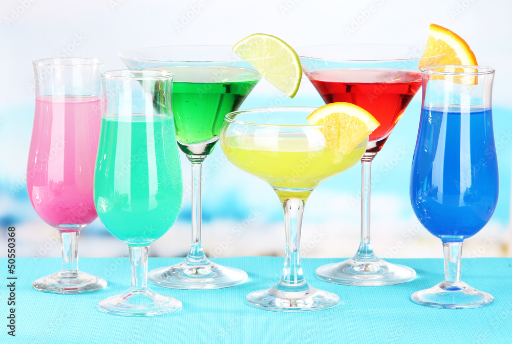 Glasses of cocktails on table near pool Glasses of cocktails on table near pool